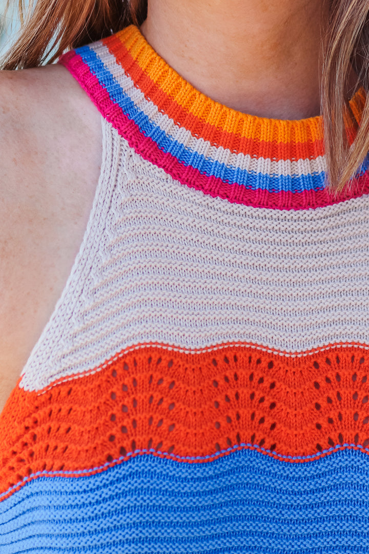 The colors on this crochet halter top are orange, hot pink, blue and taupe.