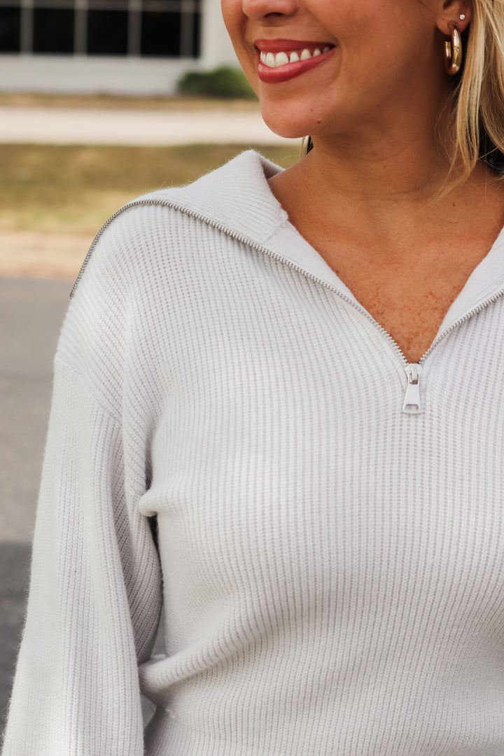 A closeup of the knit fabric and the collar with zipper.