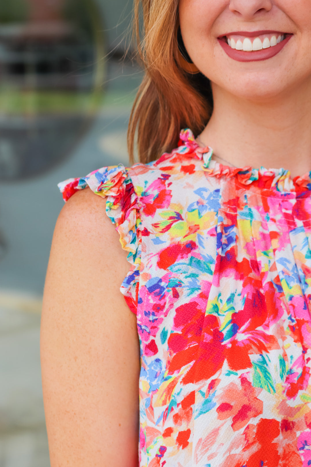 A closeup of the ruffle shoulder on the colorful button down top.